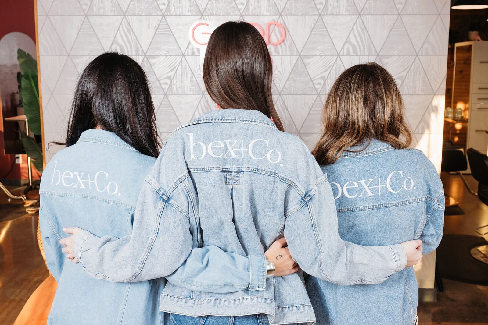 Three bex+Co.® members in matching denim jackets, arm in arm